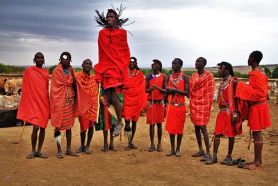 一群穿着红色西装的男人站在棕色的土地上